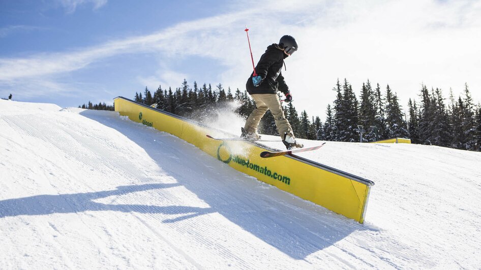 Freestyle-Skifahrer auf Rail im Superpark