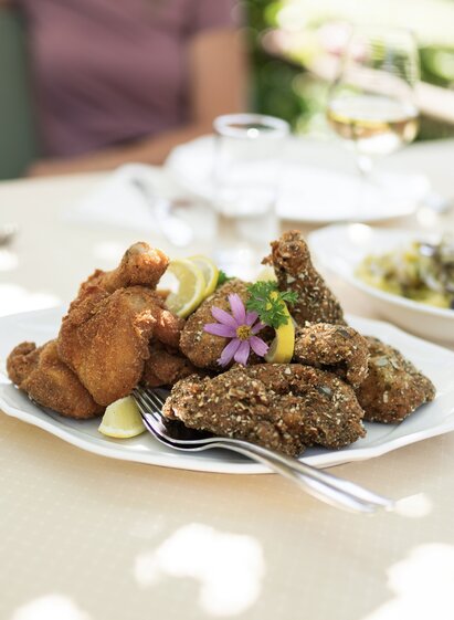 Enjoy Styrian fried chicken & beetle beans at the Buschenschank in Klöch in Thermen- & Vulkanland region in Styria