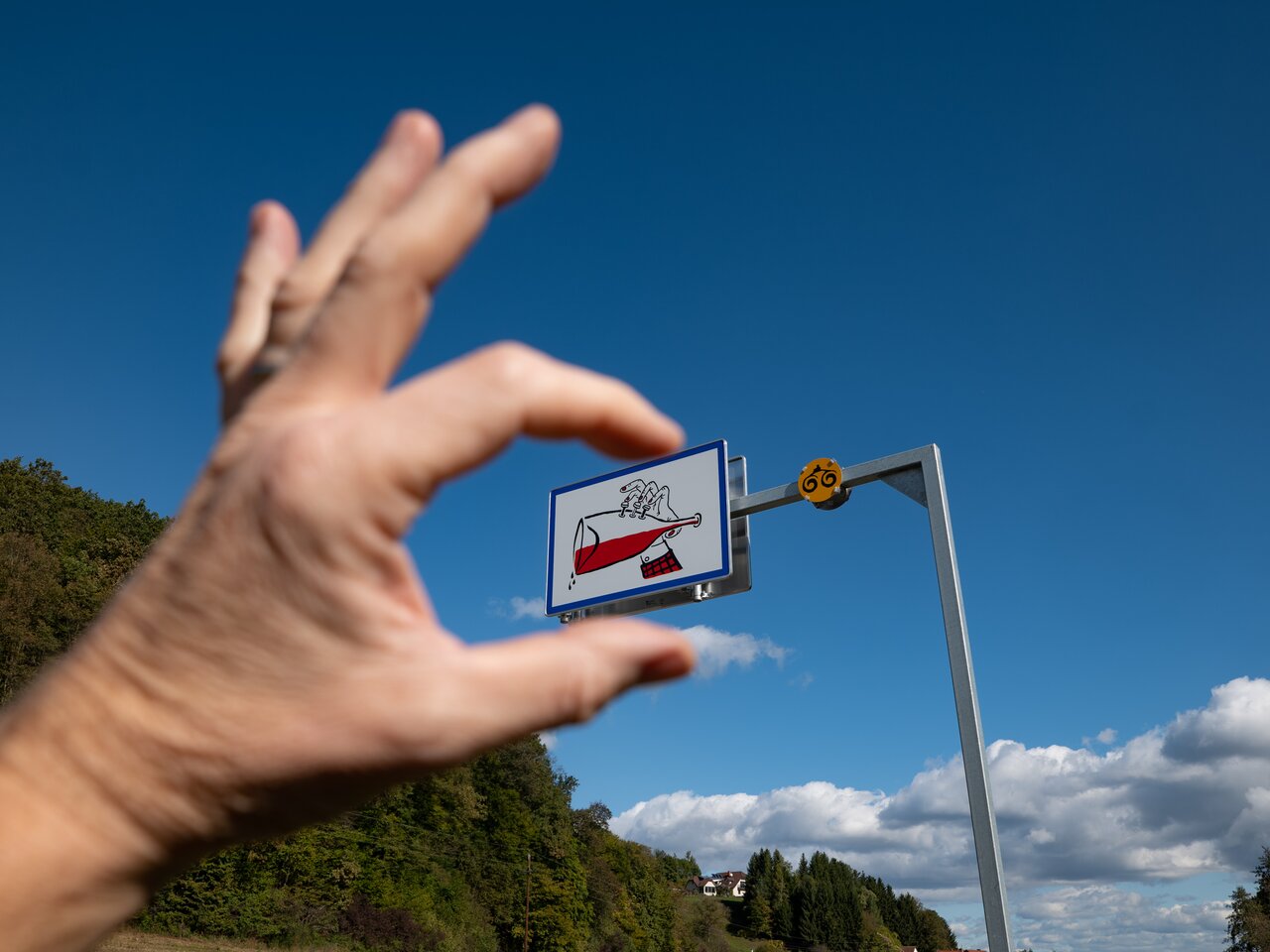 Hand fokussiert Lebenslustzeichen mit halb vollem Glas Rotwein auf der Vulkanland Route 66