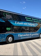 Thermenland bus on site, advertisement for the Thermen- & Vulkanland region in Styria, blue sky