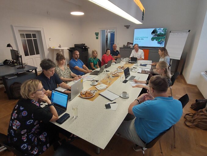 eetingraum mit Team am Tisch, Laptops und Präsentation, Thermen- & Vulkanland Steiermark