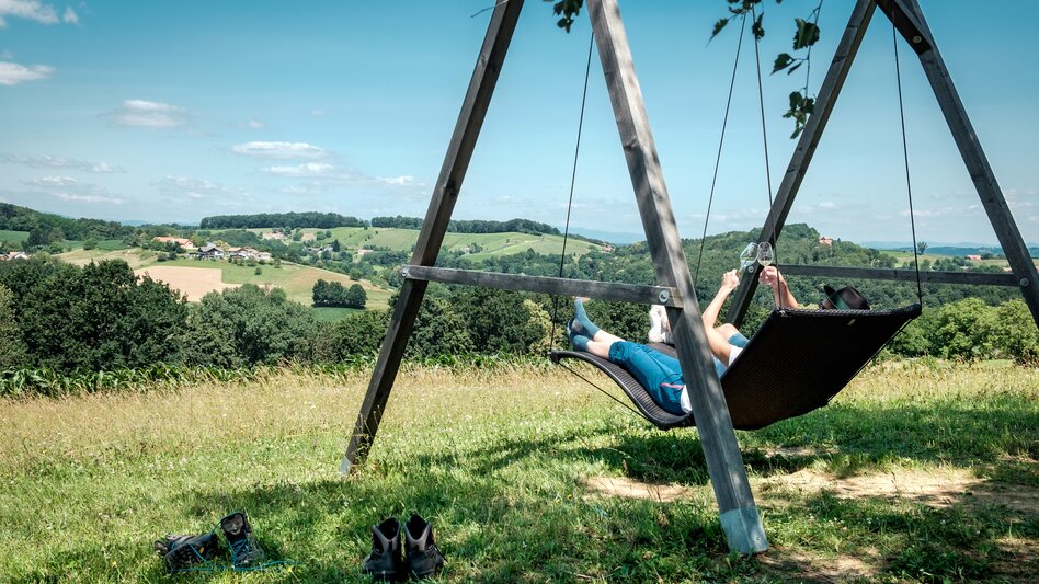 Zwei Wanderer liegen auf der Hängeschaukel am Wein-Erlebnis-Weg in Bad Loipersdorf im Thermen- & Vulkanland Steiermark