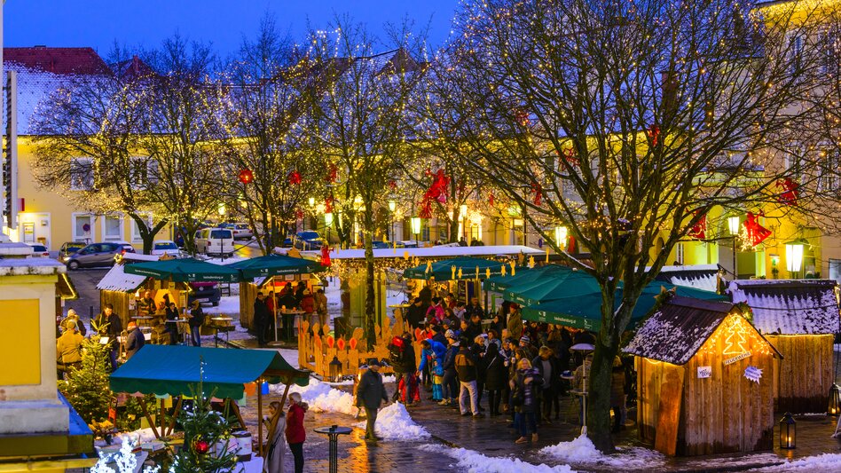 Stimmungsvoller Weihnachtsmarkt in Bad Radkersburg mit beleuchteten Adventständen, winterlicher Dekoration und Besuchern in der historischen Altstadt.