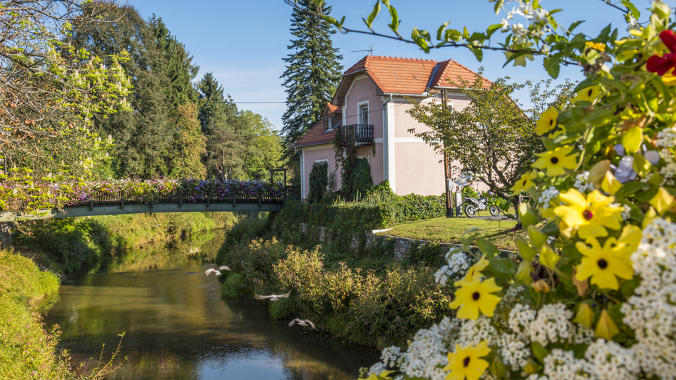 Haus mit Brücke voller bunter Blumen