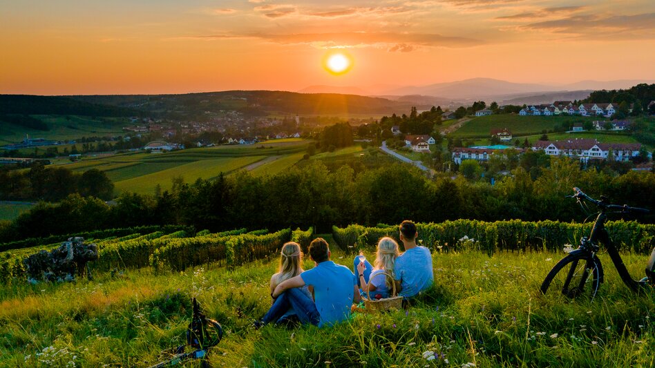 Paare genießen Sonnenuntergang mit Blick auf Weingärten | © Tourismusverband Thermen- Vulkanland, Mia's Photoart