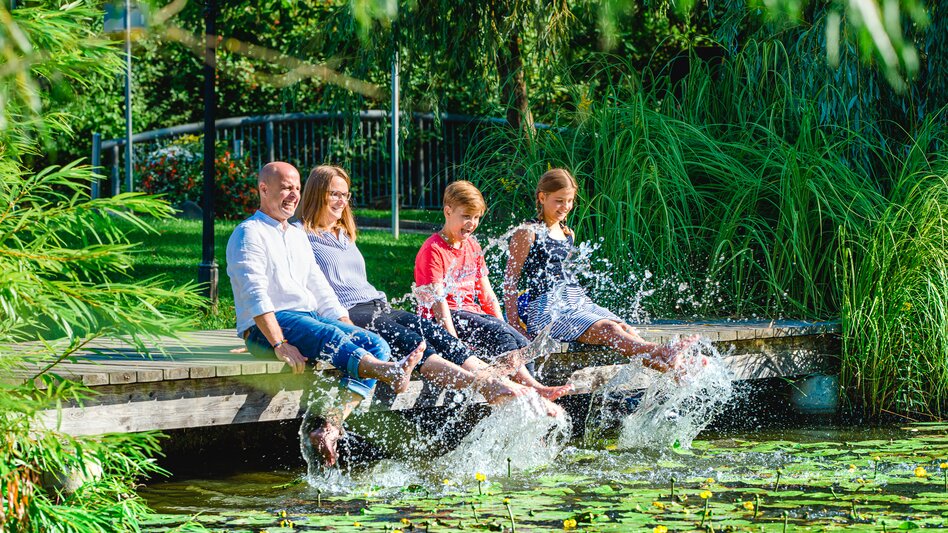 Eltern und Kinder plantschen mit Füßen im Wasser | © Tourismusverband Thermen- Vulkanland, Mia's Photoart