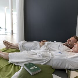 Couple relaxing on loungers in the relaxation area of the Therme der Ruhe Bad Gleichenberg in Thermen- & Vulkanland Styria
