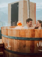 Pärchen entspannt sich in einem Holzschaffel in der Dachstein Gletscher-Sauna im Thermenresort Loipersdorf | © © Thermenresort Loipersdorf