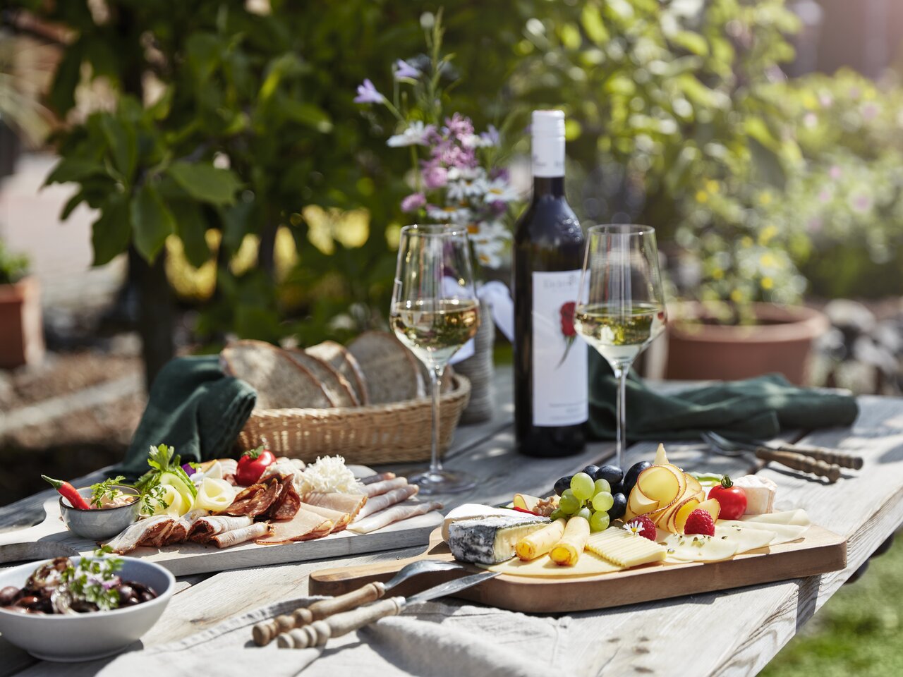Sommerliche Buschenschank-Jause mit regionalem Käse, Schinken und Weißwein im Thermen- & Vulkanland in der Steiermark.