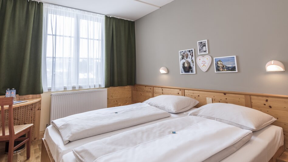 Doppelbett im Doppelzimmer im JUFA Hotel Bad Aussee mit Wandbildern | © JUFA Hotels | Günter Lenz