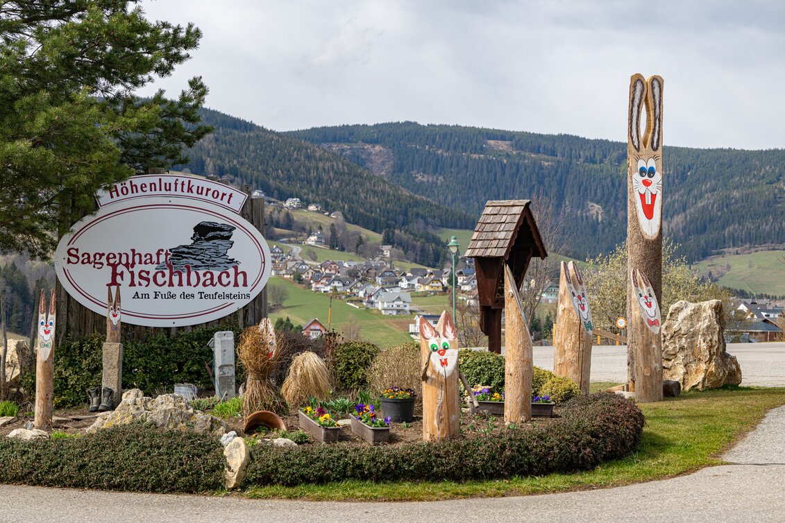 Ortstafel Fischbach umrundet von hölzernen Osterhasen | ©  Oststeiermark Tourismus | Rene Strasser