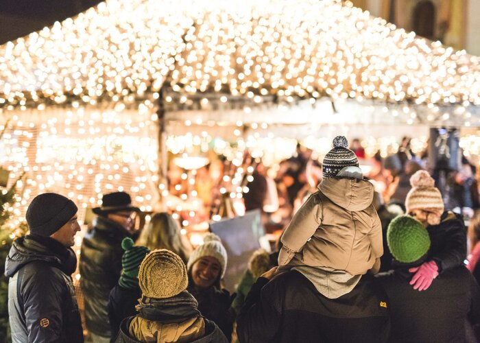 Menschenmengen auf dem Adventmarkt Gleisdorf mit Weihnachtsbeleuchtung im Hintergrund | © TV Oststeiermark | Hannes Mautner