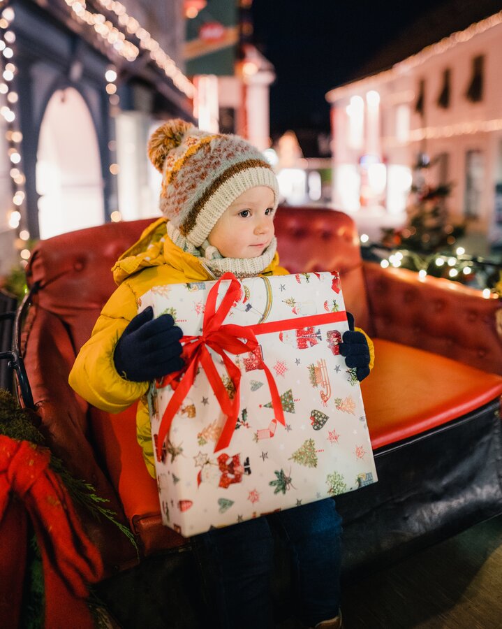 Junge mit Geschenk auf dem Weihnachtsmarkt in Hartberg