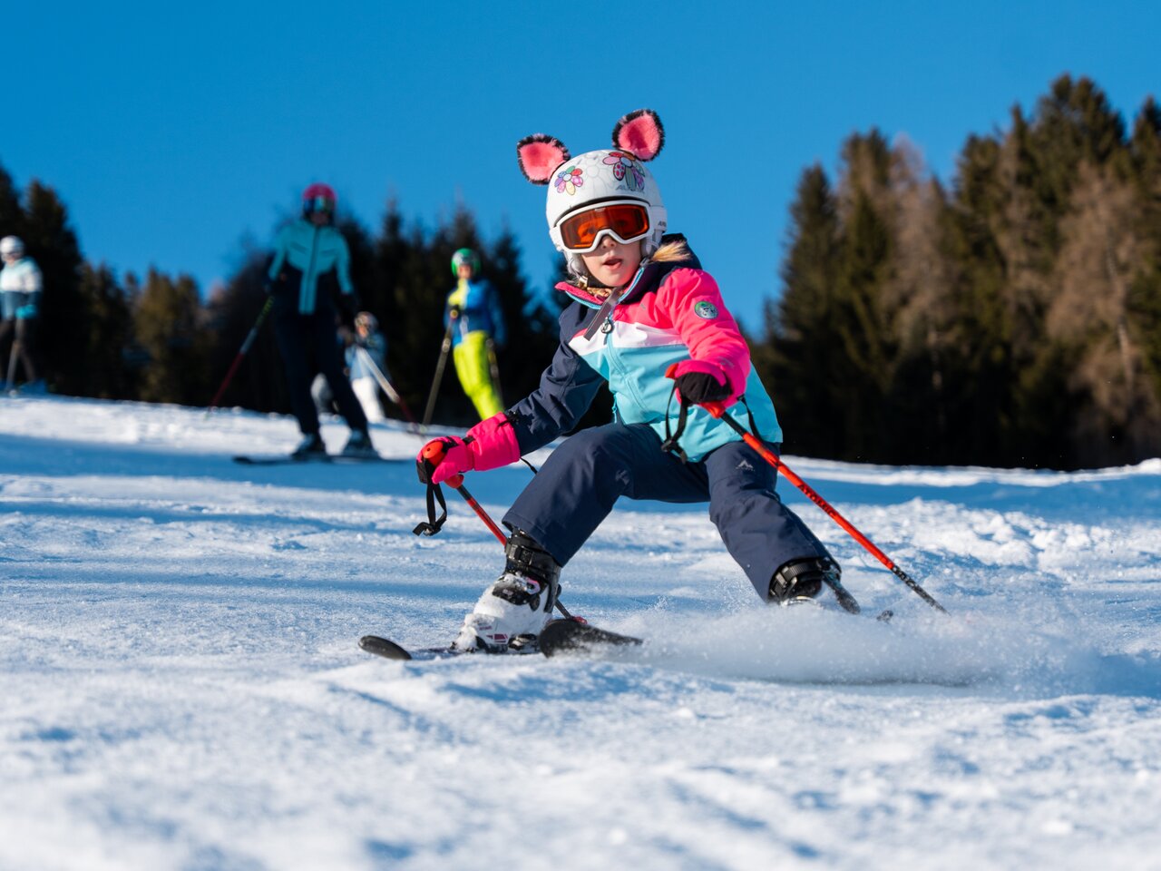 Ein junger Skifahrer genießt den Schnee unter blauem Himmel.