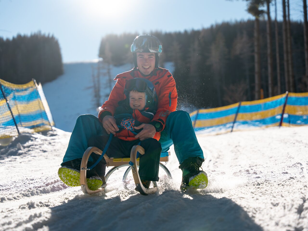 Eine fröhliche Familie genießt das Rodeln im Schnee.