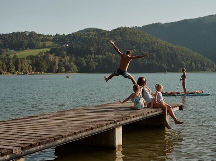 Familie sitzt am Steg vom Stubenbergsee in der Oststeiermark 