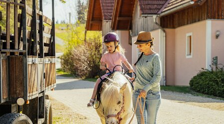 Ponyreiten mit einem Kind auf dem Land