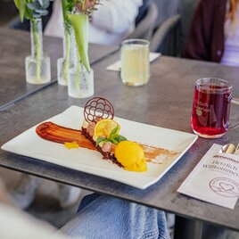 Ein kunstvoll angerichtetes Dessert mit Sorbet und Früchten.