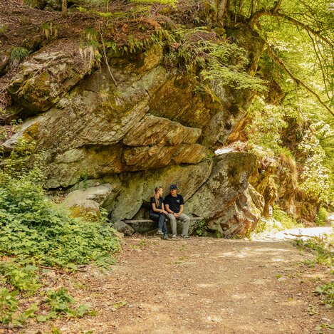 Paar entspannt unter Felsen im Wald | ©  Oststeiermark Tourismus | Noah Ulrich