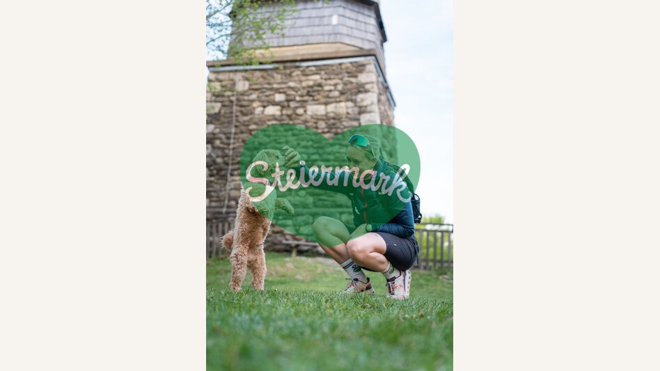 Frau spielt mit Hund vor Ringwarte | ©  Oststeiermark Tourismus | VLMMEDIA