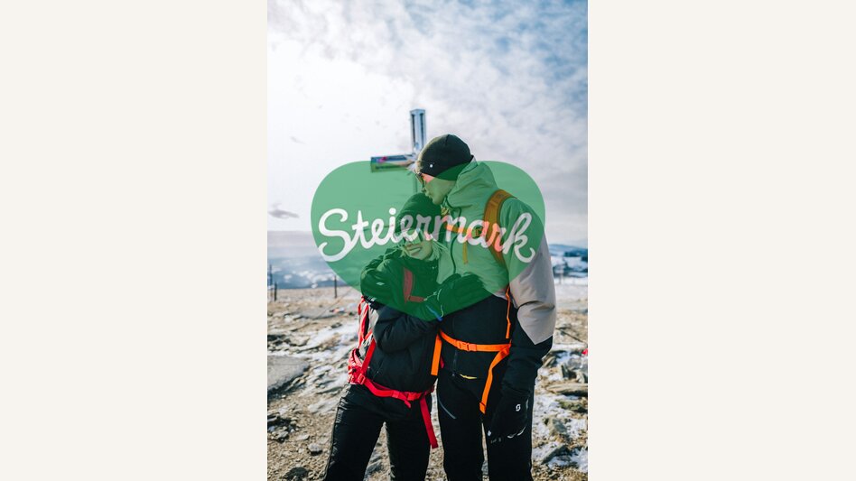 Paar beim Gipfelkreuz am Stuhleck | ©  Oststeiermark Tourismus | Noah Ulrich
