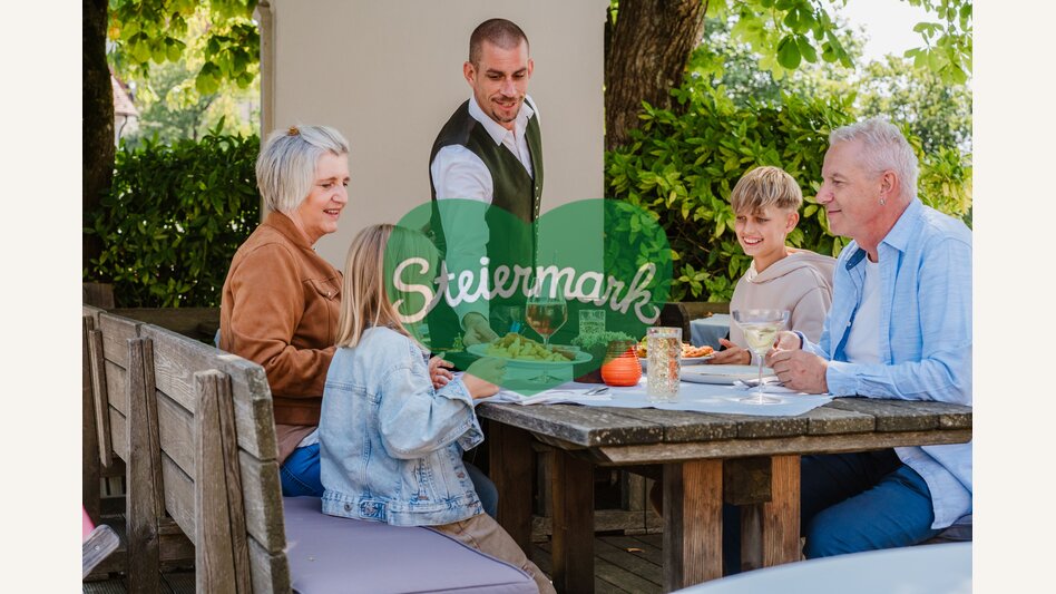 Großeltern mit Enkelkindern beim Buschenschank in der Oststeiermark. | ©  Oststeiermark Tourismus | Motion Ads