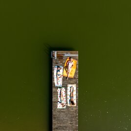 4 Personen liegen am Steg