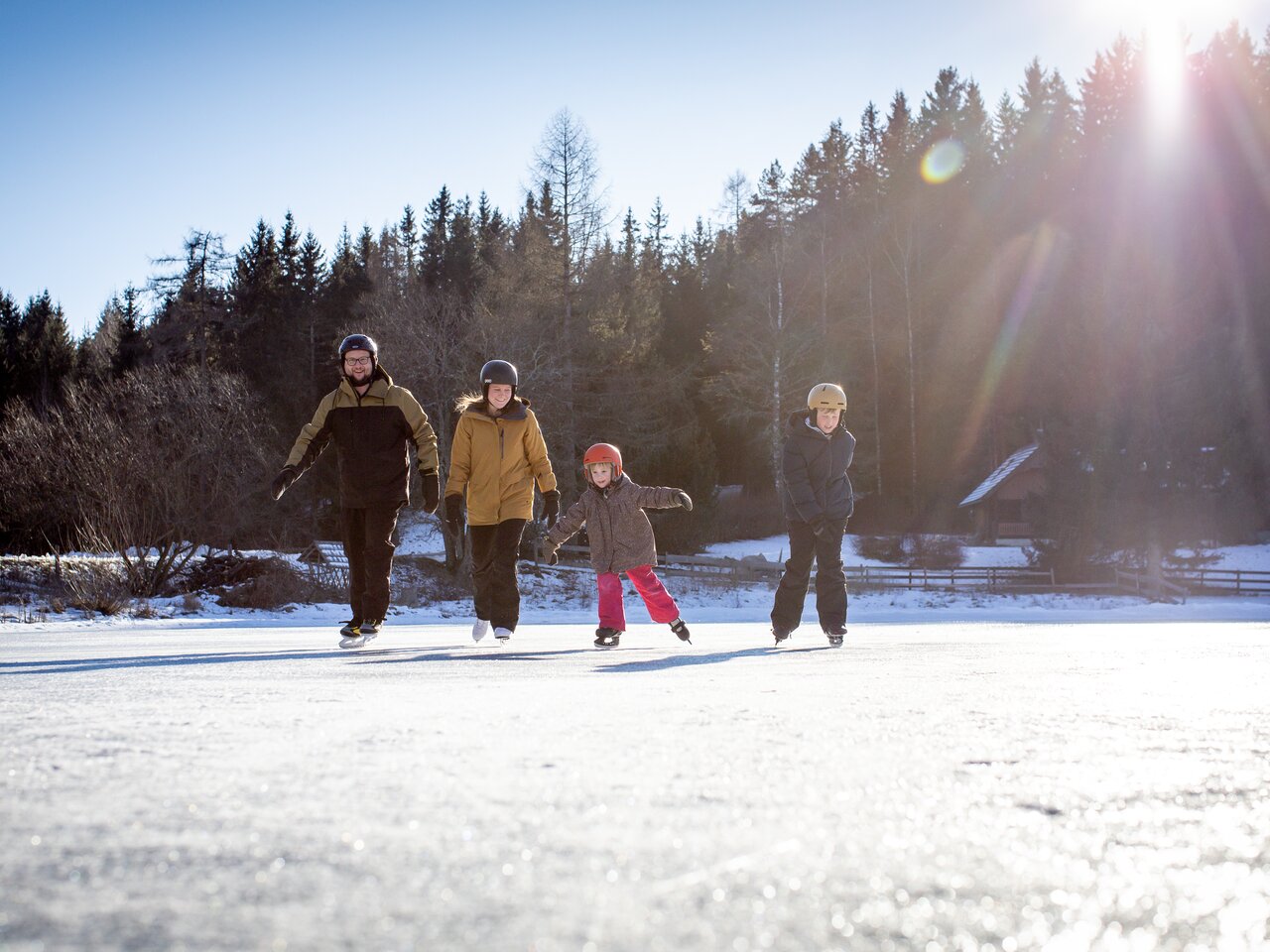 Familie beim Eislaufen am Teich