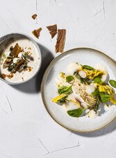 Mehrere kunstvoll angerichtete Gerichte mit regionalen Zutaten aus der Küche in Graz. | © Restaurant Schlossberg - Werner Krug
