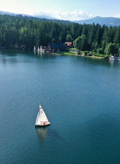 Sailboats on Lake Packer Stausee surrounded by forests and the mountain landscape of Western Styria.