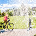 Frau mit E-Bike bei sommerlichem Radfest in Laßnitzhöhe, Steiermark