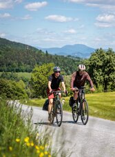 Zwei Radfahrer auf der Ligister Tour mit weitem Blick auf den Schöckl und die hügelige Landschaft