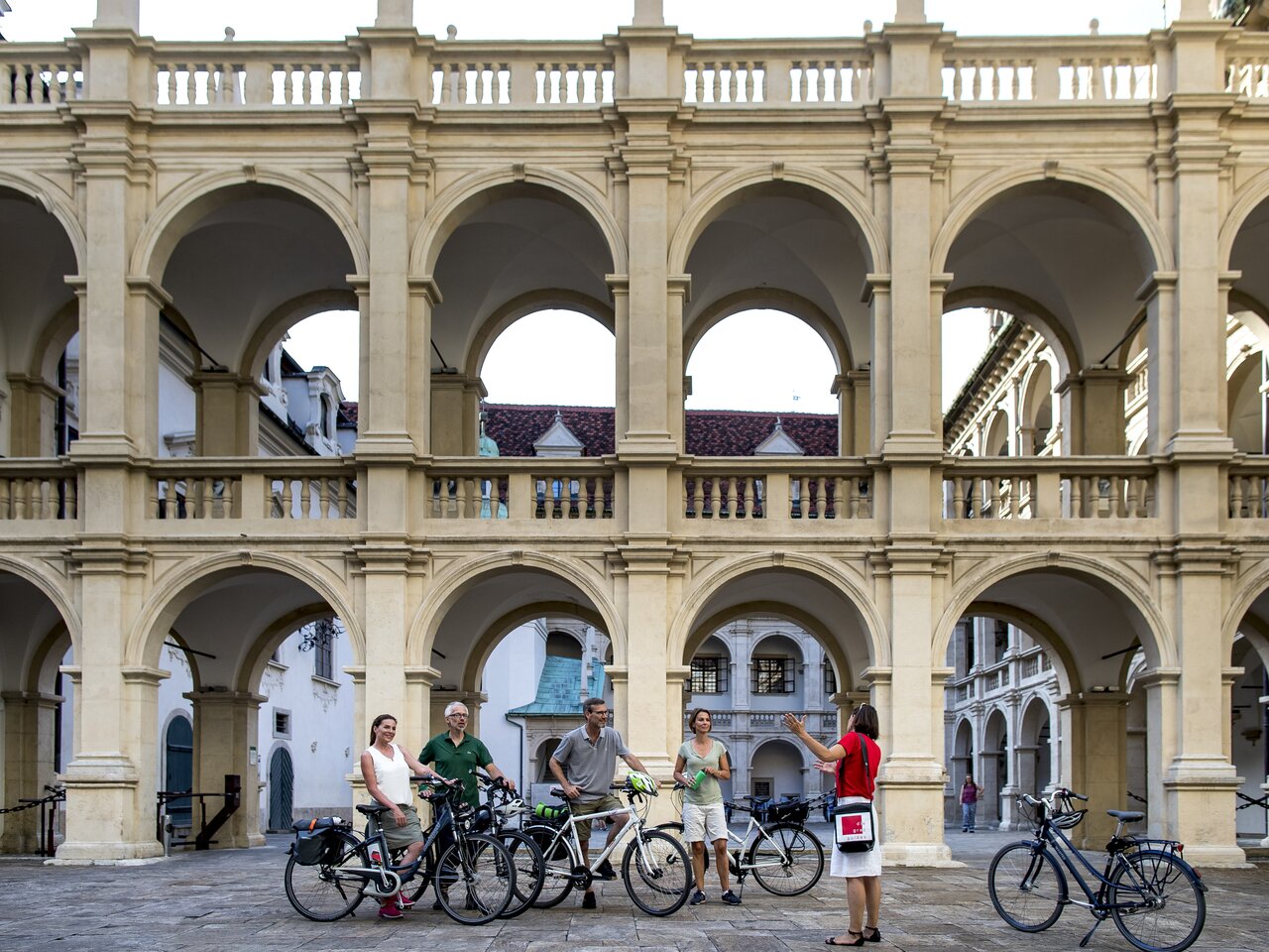 Fünf Radfahrer in den Arkaden des Landhaushofs  Arkadenhöhle der Grazer Altstadt, bei einer geführten Radtour durch die Stadt