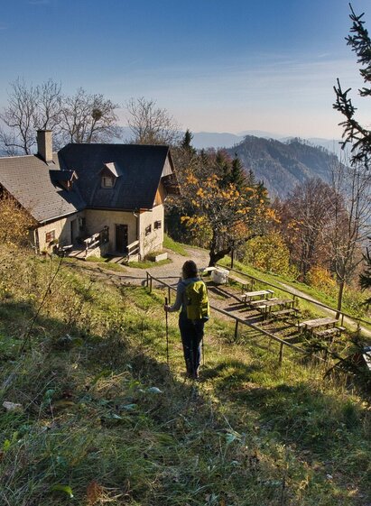 anderin nähert sich der Mühlbacherhütte mit Ausblick auf bewaldete Berglandschaft