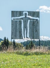 Kunstobjekt auf einer Wiese am Präbichl-Glett-Rundweg in Semriach mit Blick auf bewaldete Hügel.