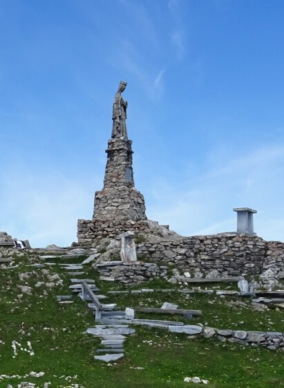 Stone statue of the Virgin Mary on a rocky pedestal at Wölkerkogel.