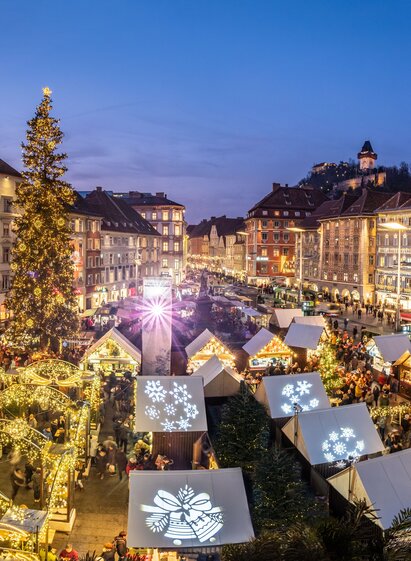 Abendlicher Weihnachtsmarkt am Grazer Hauptplatz mit Blick auf den Schlossberg