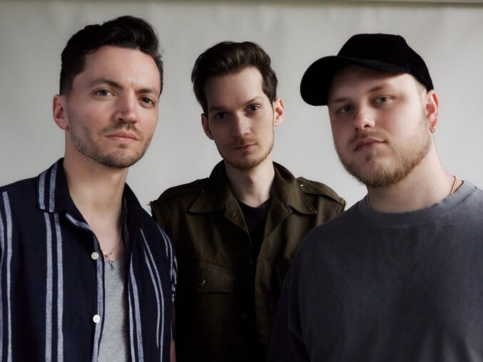 Drei Mitglieder der Band Tagtraeumer stehen nebeneinander und blicken in die Kamera.
