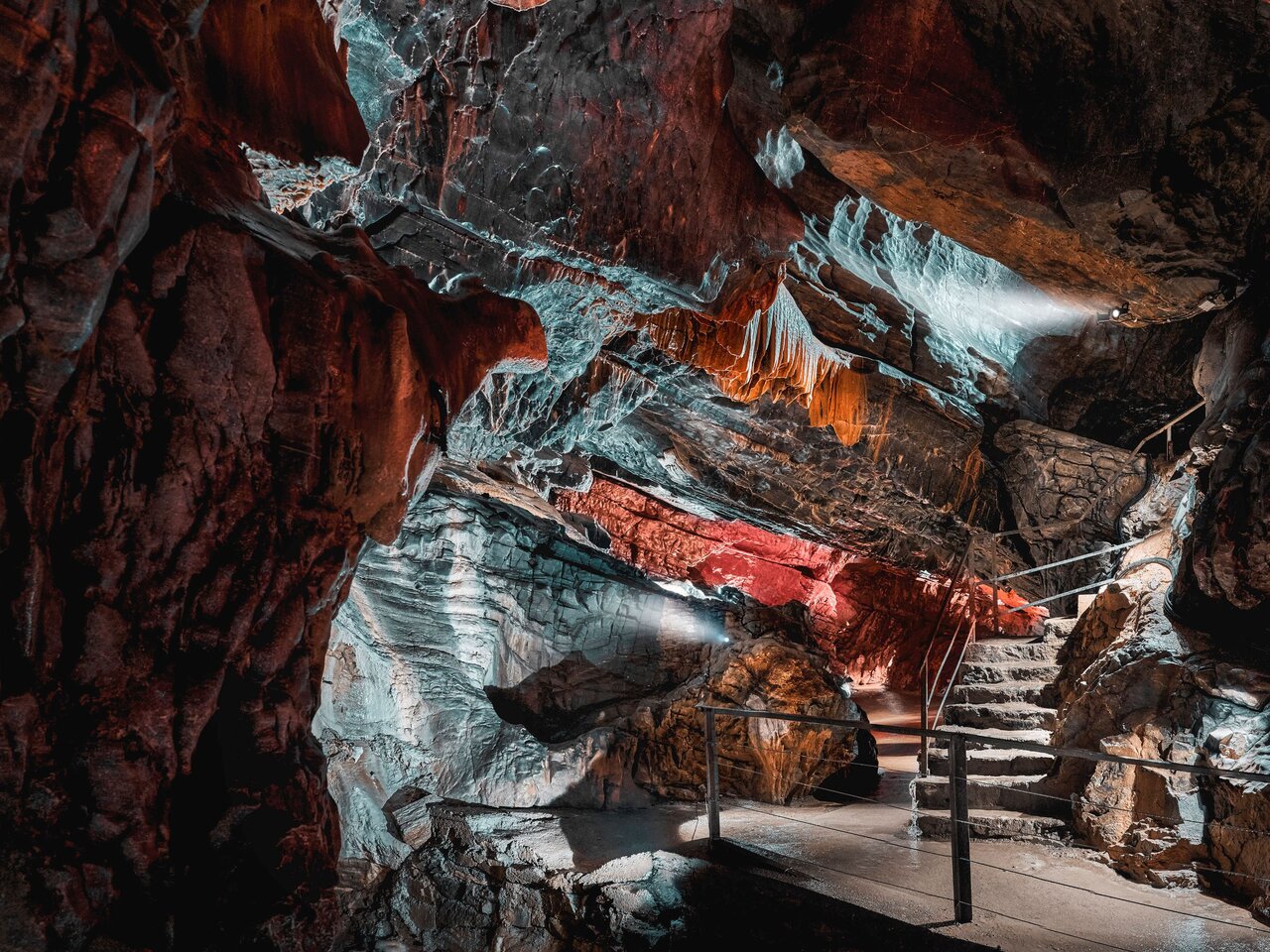 Illuminated rock formations and visitor path inside Lurgrotte Peggau