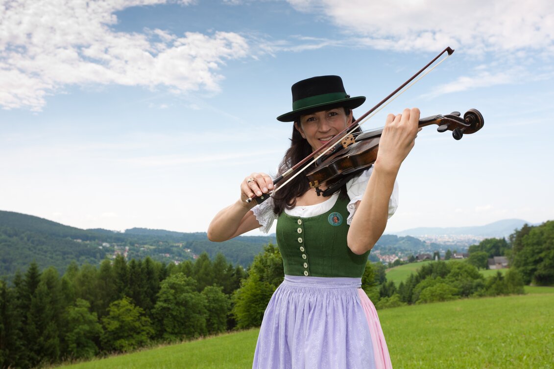 Violin player in traditional dress in Stattegg panorama | © Graz Region | Harry Schiffer