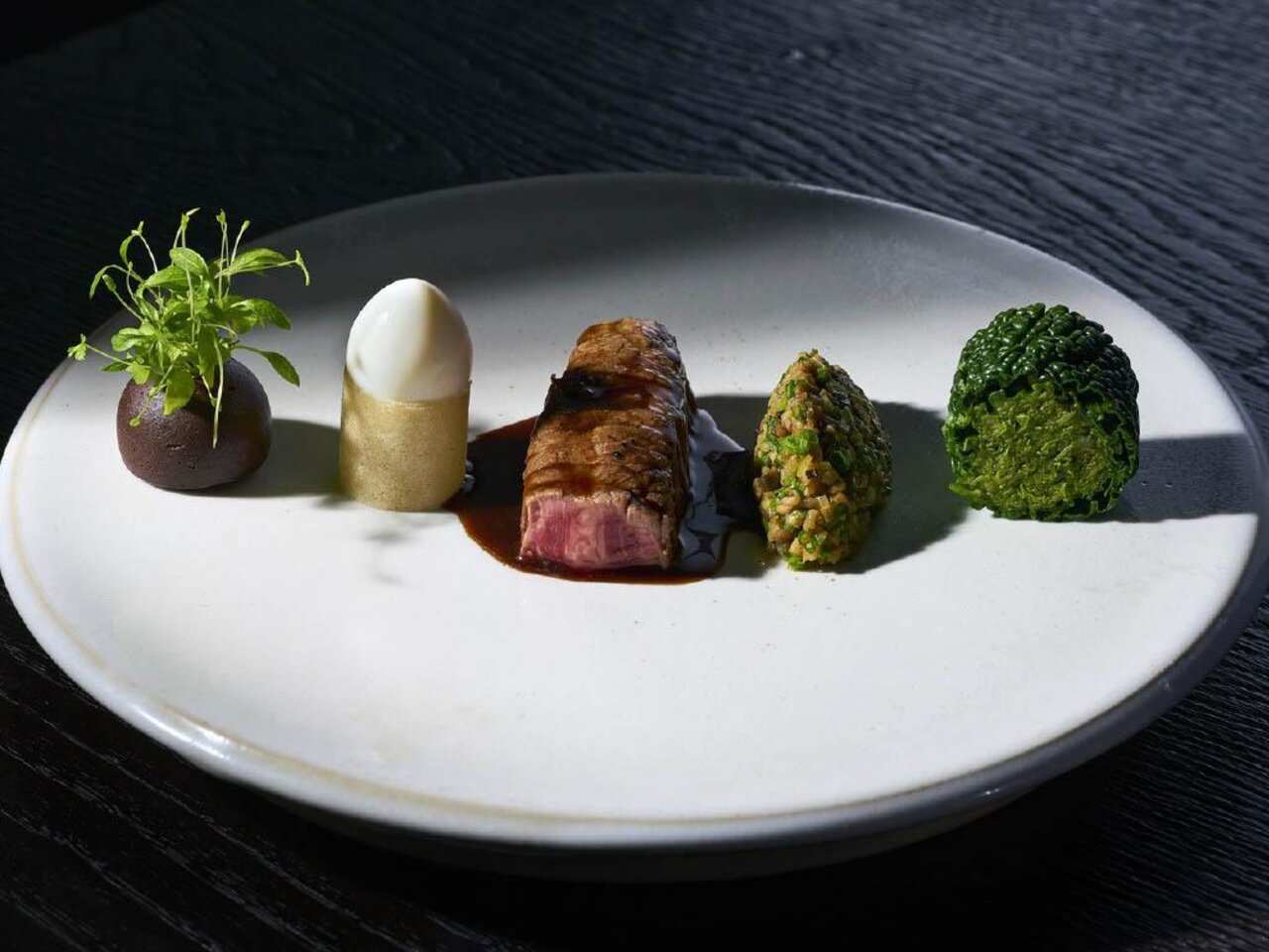 Kreativ angerichtetes Gourmetgericht mit regionalen Zutaten im Restaurant Artis in Graz.