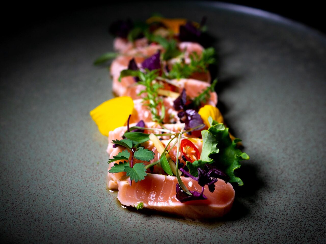 Frisches Lachs-Tataki mit Kräutern, Blüten und asiatischen Aromen im Miss Cho in Graz.