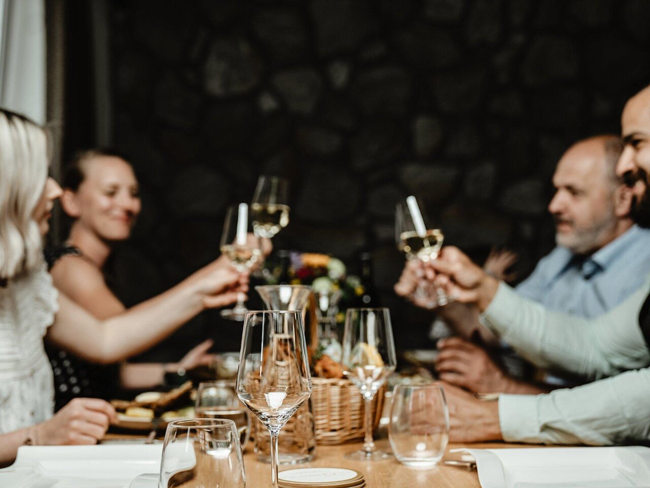 Gruppe stößt mit Wein im Wirtshaus Thorbauer in Graz bei einem gemeinsamen Abendessen an.