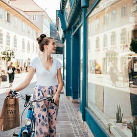 Frau mit Fahrrad beim Shopping in der Mariahilfer Straße in Graz