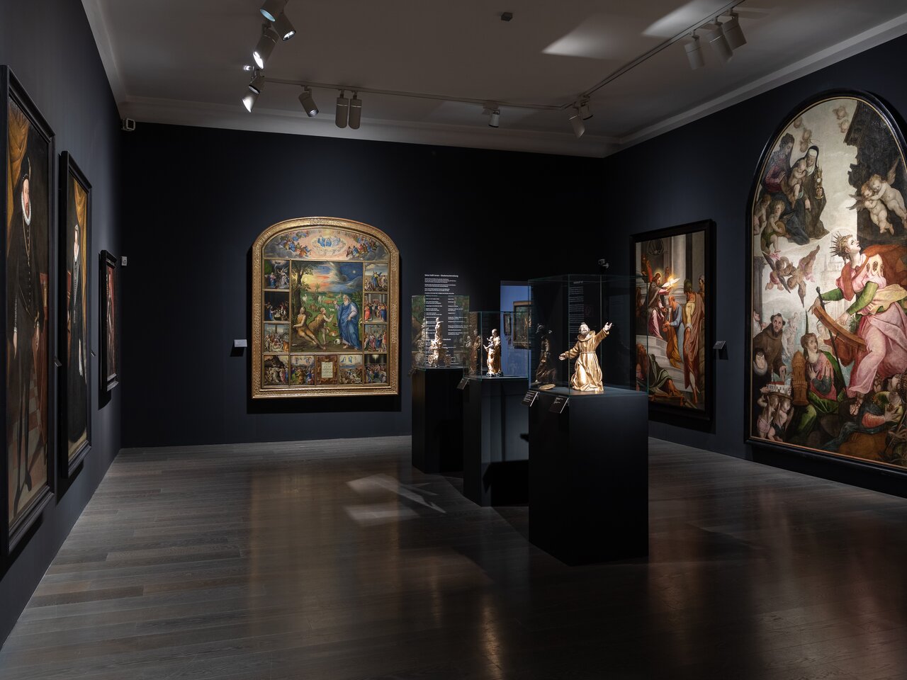 Ausstellungsraum der Alten Galerie in Schloss Eggenberg in Graz mit historischen Gemälden, Skulpturen und beleuchteten Vitrinen