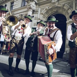 Musicians in traditional Styrian dress play trombone, trumpet, clarinet, accordion and tuba at the Aufsteirern festival in Graz.