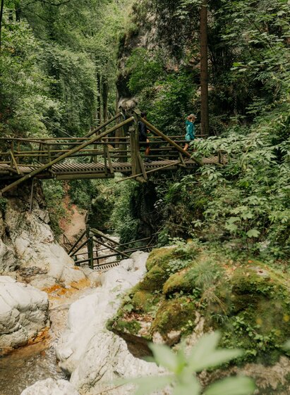 Wanderweg mit Holzbrücke über Felsbach in der Kesselfallklamm