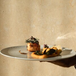 Teller mit Filetsteak garniert mit Rosmarin auf Polenta