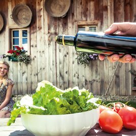 Grüner Salat wird mit Kernöl mariniert