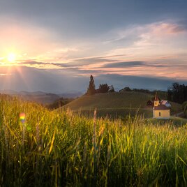 Kapelle steht im letzten Sonnenschein auf einen Hügel